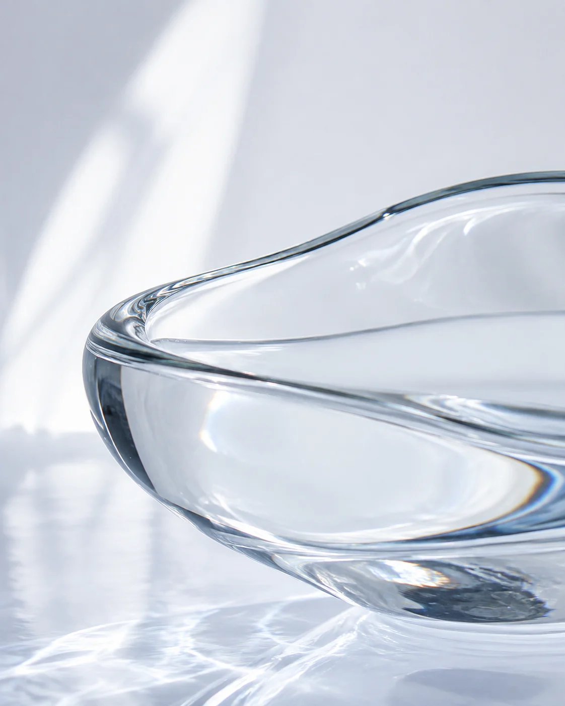 Still water and sculptural glass in soft daylight